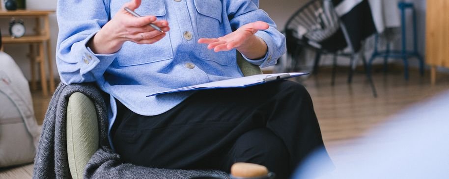 Psicóloga conversando con una persona adulta durante una sesión en consulta