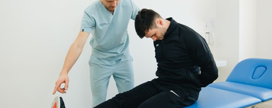 Profesional de rehabilitación acompañando a un paciente durante una sesión clínica tras un daño neurológico